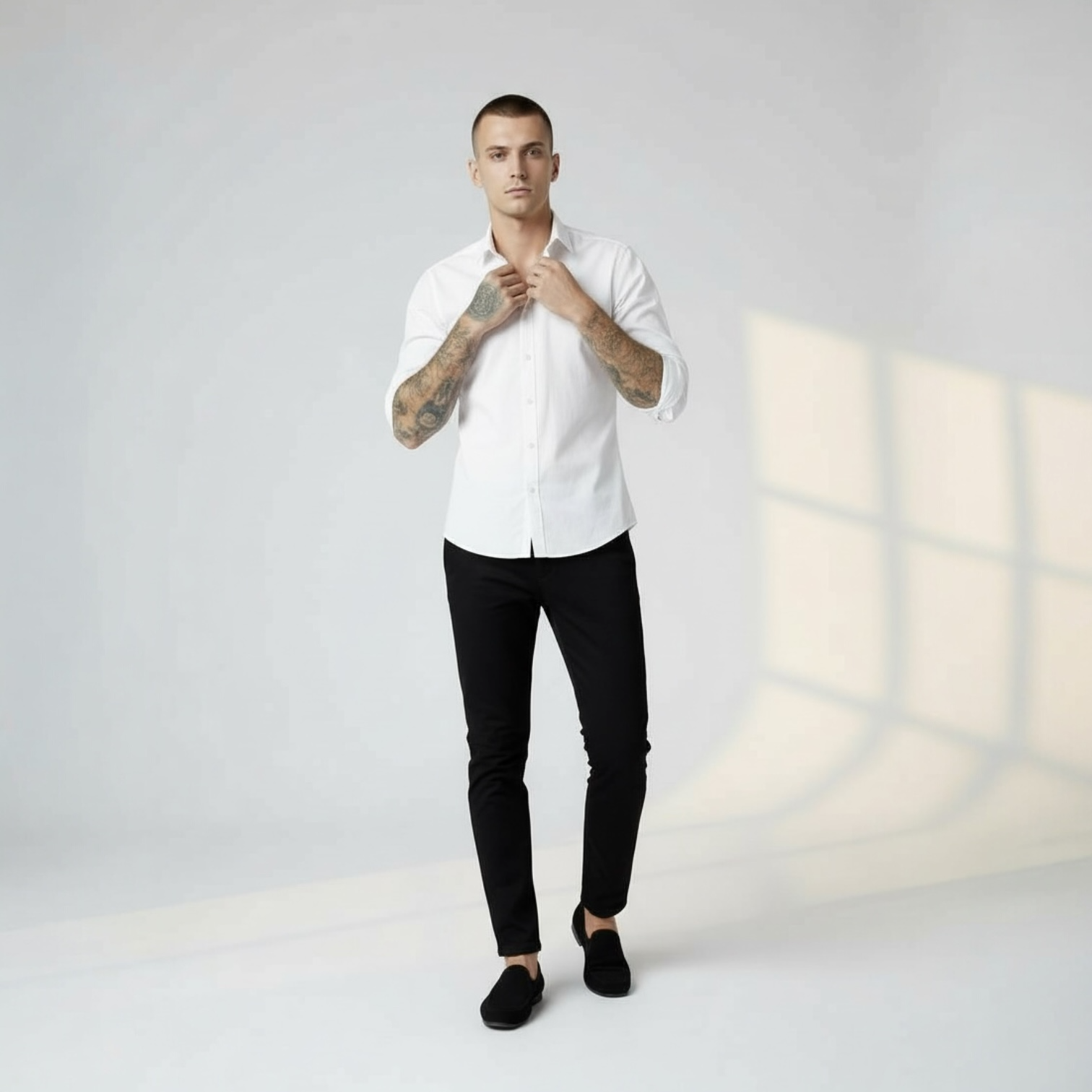 Mann in weißem Hemd und schwarzer Hose von DMANERA Atelier vor hellem Hintergrund