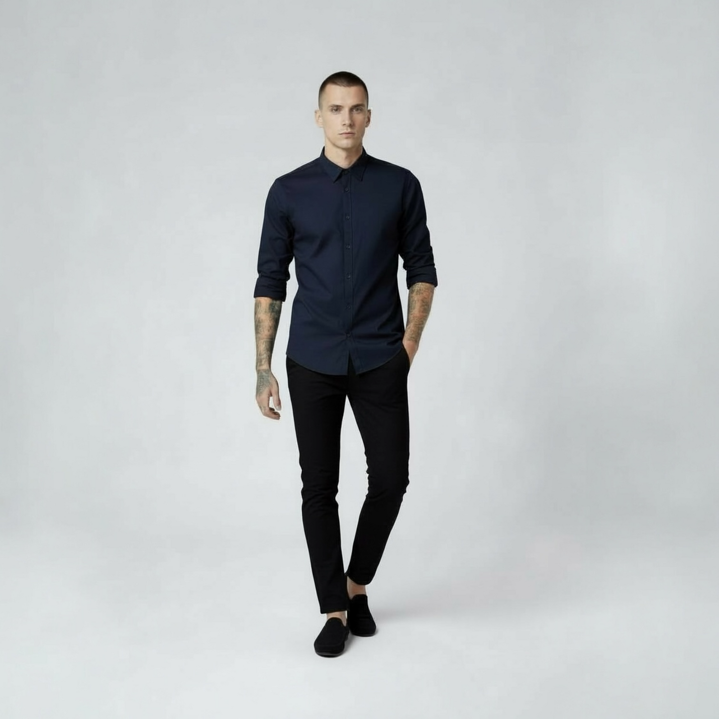 Mann in dunkelblauem Hemd und schwarzer Hose von DMANERA Atelier vor hellem Hintergrund