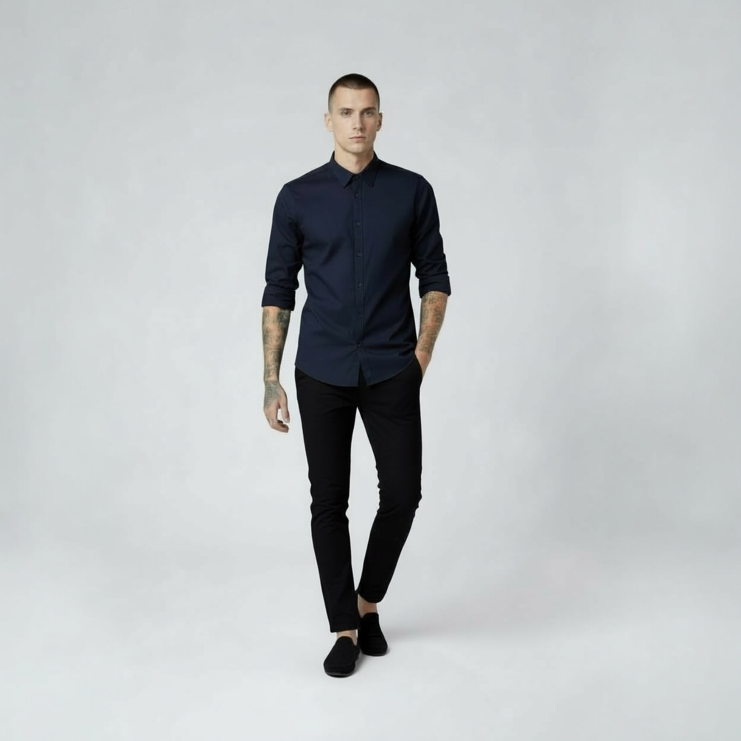 Mann in dunkelblauem Hemd und schwarzer Hose von DMANERA Atelier vor hellem Hintergrund